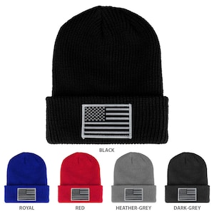 Pode incluir: Um conjunto de dez gorros de malha em várias cores, cada um com um pequeno remendo bordado da bandeira americana. As cores incluem preto, vermelho, azul royal, cinza mesclado e cinza escuro.