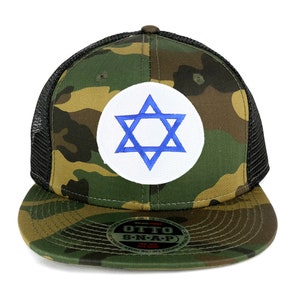 Könnte beinhalten: Eine Camouflage-Trucker-Kappe mit einem weißen Kreis und einem blauen Davidstern auf der Vorderseite. Die Kappe hat ein schwarzes Netzrücken und einen schwarzen Druckknopfverschluss. Die Kappe ist mit "OTTO S-N-A-P" beschriftet.