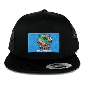 May include: Black trucker hat with a blue and white embroidered patch of the Oklahoma state flag. The patch features the state's official seal, which depicts a Native American holding a spear and a peace pipe. The hat has a black mesh back and a black snap closure.