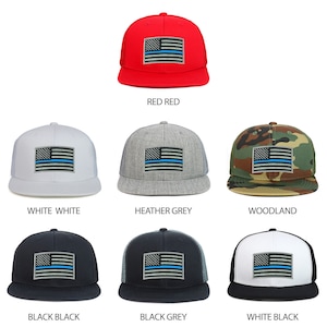 Può includere: Nove diverse combinazioni di colore e tessuto per un cappello da baseball con una toppa di bandiera americana a linea blu sottile. I cappelli sono disponibili in rosso, bianco, grigio melange, mimetico, nero e grigio scuro.