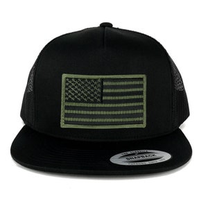 May include: Black and green trucker hat with an embroidered American flag patch. The hat has a black mesh back and a black snap closure. The hat is labeled "The Classic Snapback Yupoong Since 1975".