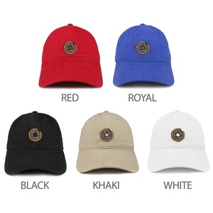 May include: Five different colored baseball caps with a donut graphic embroidered on the front. The caps are available in red, royal blue, black, khaki, and white.