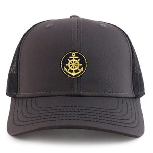 May include: A black and gold trucker hat with an embroidered anchor and steering wheel design.