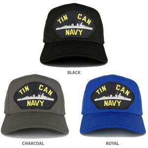 以下が含まれることがあります： 黄色い文字で「Tin Can Navy」と書かれた紺色のパッチが付いたベースボールキャップが3つ。キャップの色は黒、チャコールグレー、ロイヤルブルーです。