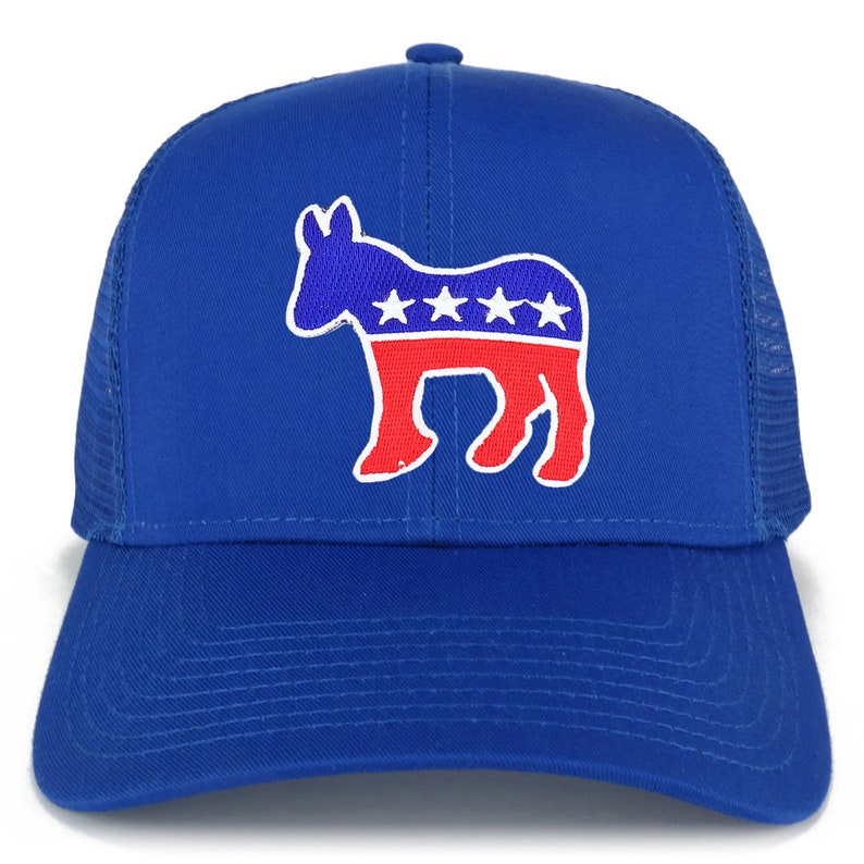 Op de afbeelding: Een koninklijk blauwe trucker-pet met een rood, wit en blauw ezel-silhouet met vijf witte sterren. De ezel is een politiek symbool.