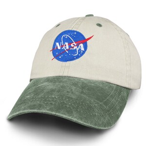 May include: A beige and green baseball cap with an embroidered NASA logo in blue, red, and white.