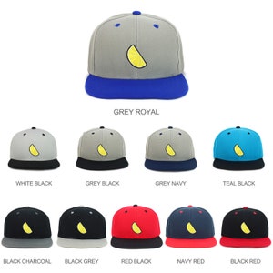 May include: A selection of baseball caps with a lemon slice design. The caps are available in various color combinations, including grey and royal blue, white and black, grey and black, grey and navy, teal and black, black and charcoal, black and grey, red and black, navy and red, and black and red.