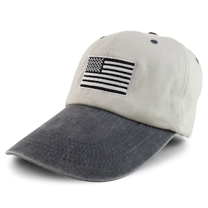 May include: A beige baseball cap with a black and white American flag patch on the front. The cap has a dark grey, distressed denim bill.