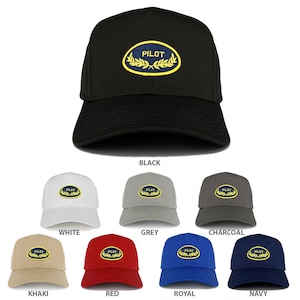 Puede incluir: Un conjunto de diez gorras de béisbol en varios colores, cada una con un parche azul marino con la palabra "PILOT" en letras amarillas y una corona de laurel dorada.