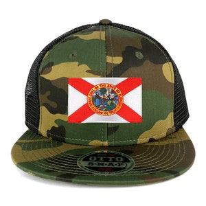 May include: A black and green camouflage trucker hat with a black mesh back. The hat features a patch of the Florida state flag with the words "Great Seal of the State of Florida" and "In God We Trust". The hat has a snap closure.