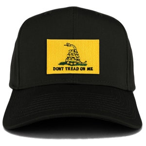 Könnte beinhalten: Eine schwarze Baseballkappe mit einem gelben Patch, auf dem eine sich windende Schlange und der Text "Don't Tread On Me" zu sehen sind.