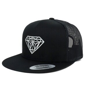 May include: Black and white diamond embroidered on a black mesh trucker hat. The hat has a black brim and a black mesh back. The hat has a white label that says "The Authentic" and "Snapback" with the text "Fufong Since 1914" underneath.