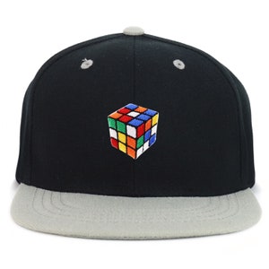 May include: A black and gray baseball cap with a colorful Rubik's Cube design embroidered on the front.