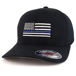 May include: Black baseball cap with an embroidered American flag with a blue line. The cap has a Flexfit label on the back that says "The Original Flexfit XL/XXL It Fits Your Life".