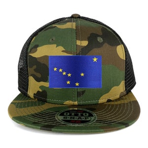 Può includere: Un cappello da camionista mimetico nero e verde con una bandiera ricamata dell'Alaska blu e gialla sul davanti. Il cappello ha una rete nera sul retro e una chiusura a scatto.