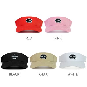 May include: Six sun visors in different colors: red, pink, black, khaki, white. Each visor has a black speech bubble with the word "OOPS" in white letters.