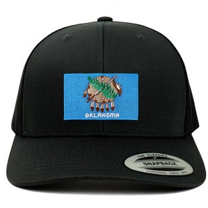 May include: Black trucker hat with a blue and white Oklahoma state flag patch on the front. The hat has a black mesh back and a black snap closure.