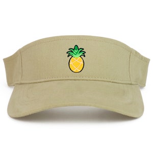 May include: A khaki visor with an embroidered pineapple design. The pineapple is yellow with green leaves.