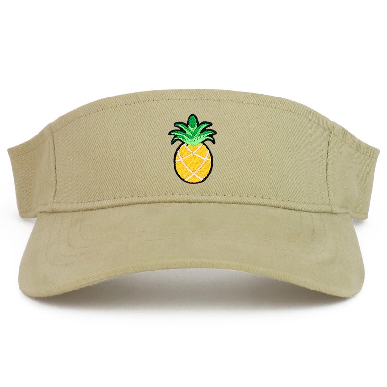 May include: A khaki visor with an embroidered pineapple design. The pineapple is yellow with green leaves.
