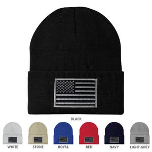 May include: A collection of ten knit beanies in various colors, each featuring a gray embroidered American flag patch. The colors include white, stone, royal blue, red, navy, and light gray.
