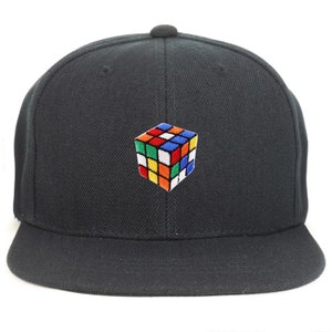 Op de afbeelding: Een zwarte baseballpet met een kleurrijk Rubik's Cube geborduurd op de voorkant.