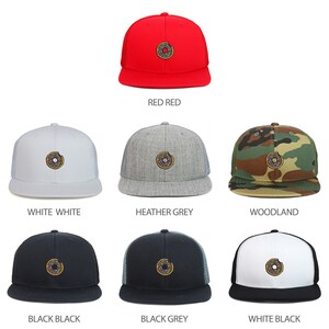 May include: A collection of snapback baseball caps in various colors, including red, white, heather grey, woodland camouflage, black, and black and grey. Each cap features an embroidered donut design.
