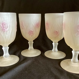 May include: Set of four frosted glass goblets with a floral design. The goblets are a pale yellow color with pink flowers and leaves.