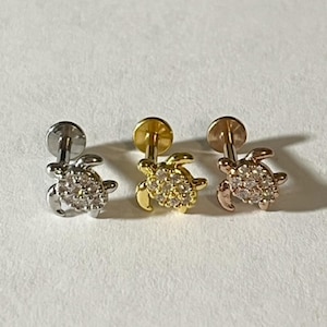 May include: Three silver, gold, and rose gold turtle stud earrings with clear rhinestones.