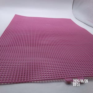 May include: A square pink plastic canvas sheet featuring a uniform grid of small, evenly spaced holes throughout its surface. A small tab extends from one edge, and the date 2026/06/26 03:31 is printed in white text in the bottom right corner.