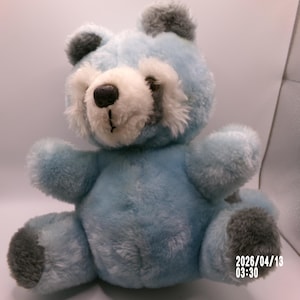 May include: A white ceramic mug with a black handle and the text "But First, Coffee" in a black, bold font. The mug is sitting on a white surface. The mug is approximately 4 inches tall.