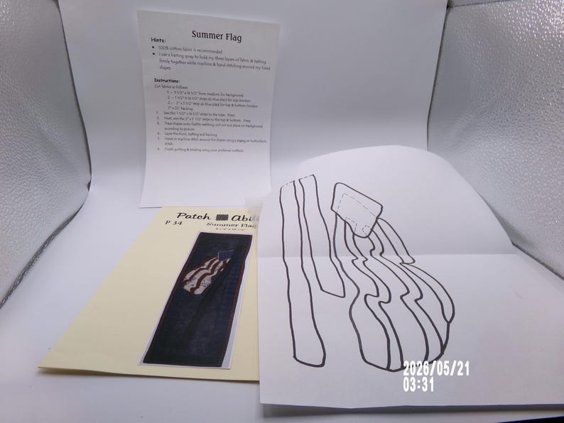 May include: A craft project with instructions for a "Summer Flag" patch. The image shows a printed pattern, a sketch, and a sheet of instructions. The patch design features a stylized American flag with red and white stripes and blue background.