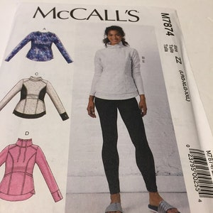 May include: McCall's sewing pattern M7874 featuring a woman wearing a light gray mock neck top and black leggings. The pattern includes illustrations of different top designs. The size range is LRG-XXL.
