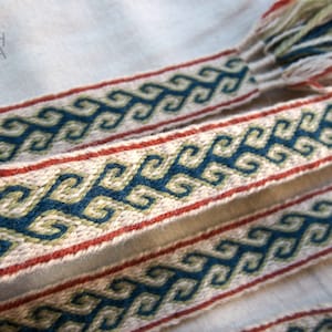 Peut inclure: Deux bandes de tissu tissées avec un motif géométrique dans des tons de bleu, vert et rouge. Les bandes sont faites de fibres naturelles et ont un aspect rustique et artisanal.