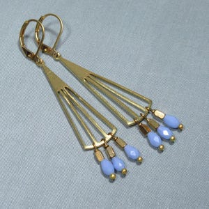 May include: Gold earrings with a geometric design and light blue glass beads.