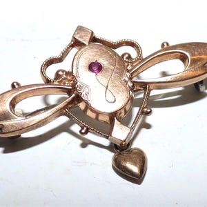 Broche Art Nouveau victoriano de oro rosa enrollado: Corazón de pasta de rubí con forma de gota