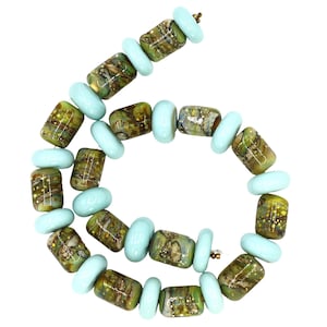 May include: A necklace featuring a series of green and brown patterned cylindrical beads interspersed with light blue, oval-shaped beads. The beads are strung together with a gold-colored clasp, creating a unique jewelry piece.