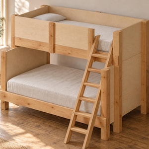 Puede incluir: Una litera de madera de color claro con una estructura robusta de postes de soporte verticales, una barandilla protectora en la cama superior y una escalera fija de cuatro peldaños. Ambas camas cuentan con colchones de color blanco.
