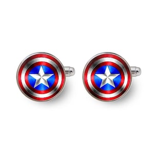 May include: A pair of silver cufflinks featuring a red, white and blue American flag design. The cufflinks are circular with a white star in the centre.