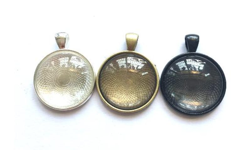 May include: Three round glass pendant trays with silver, gold, and black metal frames. The glass is clear and has a textured pattern.