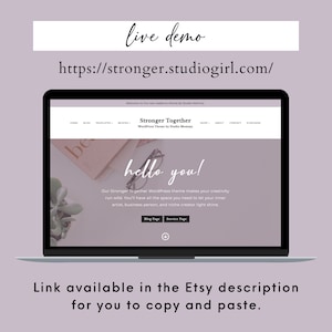 May include: A laptop computer displaying a website for a WordPress theme called "Stronger Together". The website has a light pink background with the text "hello you!" in a large, handwritten font. The text "Our Stronger Together WordPress theme makes your creativity run wild. You'll have all the space you need to let your inner artist, business person, and niche creator light shine." is below the greeting. The website also includes buttons for "Blog Page" and "Service Page".