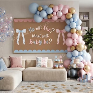 May include: A gender reveal party scene with a large brown sign that reads "He or She? What will Baby be?" in pink and blue. A balloon arch in gold, pink, and blue decorates the room. A sofa with pillows and a cake with the word "Guess" are also visible.