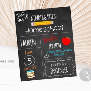 Op de afbeelding: Een printbaar bord van 20,3 x 25,4 cm voor de eerste dag van de thuisschool van een kind. Het bord is zwart met witte tekst en kleurrijke illustraties. Het staat "Eerste dag van de thuisschool" en bevat de naam van het kind, zijn leeftijd en zijn toekomstige carri&egrave;reaspiraties.