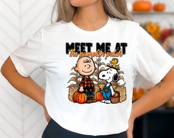 May include: White t-shirt with a graphic of Snoopy and Charlie Brown holding pumpkins. The text "Meet me at the pumpkin patch" is printed on the shirt.