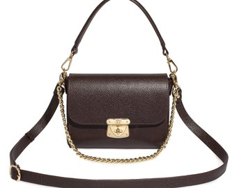 May include: A brown leather shoulder bag with a gold chain strap and a gold lock closure.