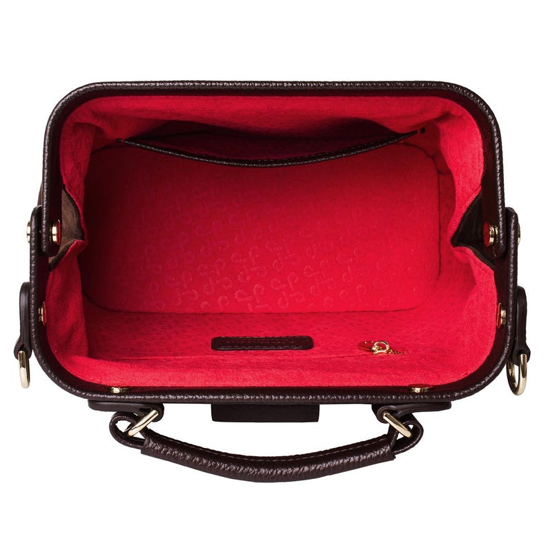 May include: A brown leather handbag with a red interior and gold hardware. The bag has a top handle and a zip closure.