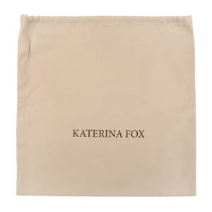 May include: A beige drawstring dust bag with the text "KATERINA FOX" printed in brown.