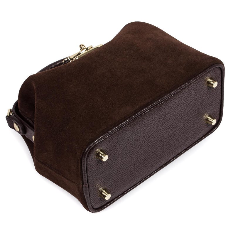 May include: A brown suede and leather handbag with a gold clasp and four gold feet.