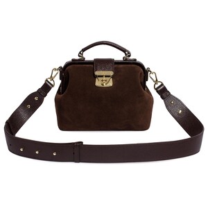 May include: A brown leather doctor's bag with a gold clasp and a long adjustable strap.