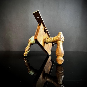 May include: Antique door hardware with two rusty metal handles and a metal plate with a keyhole. The handles are painted a faded green color.