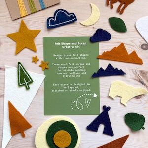 May include: A collection of felt shapes in various colors, including yellow stars, blue clouds, and brown mountains. The shapes are part of a creative kit with iron-on backing, designed for mending, collage, and storytelling. The kit includes the text "Felt Shape and Scrap Creative Kit".